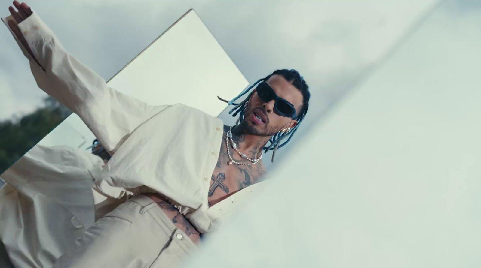 a man with dreadlocks wearing sunglasses and a white shirt