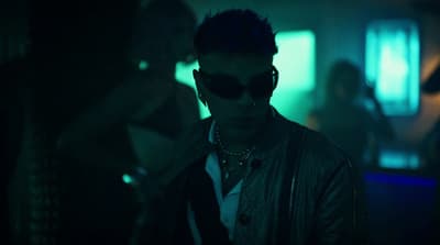 a man wearing sunglasses and a leather jacket