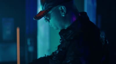 a man in a black jacket and a red hat