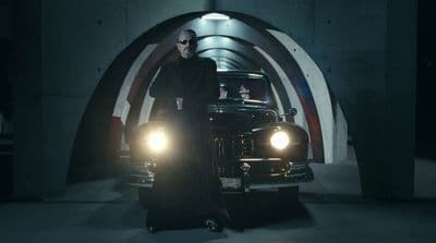 a man standing next to a car in a tunnel