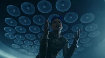 a woman standing in front of a ceiling of bubbles