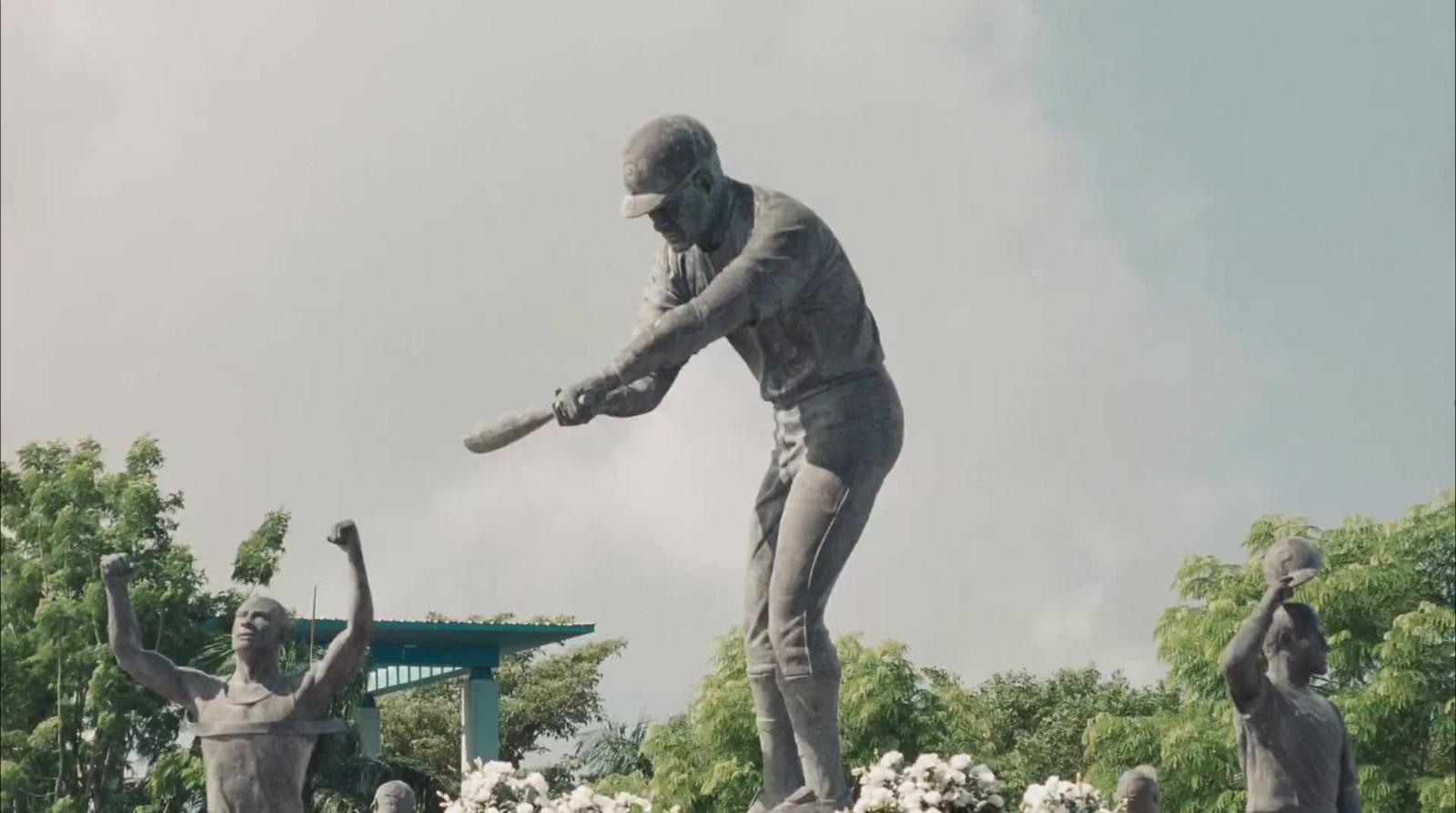 a statue of a man swinging a baseball bat