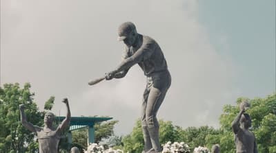 a statue of a man swinging a baseball bat