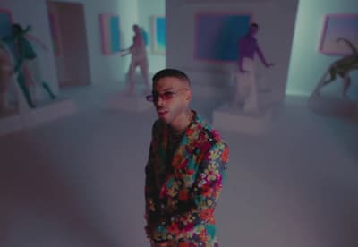 a woman standing in a room with a bunch of people in the background
