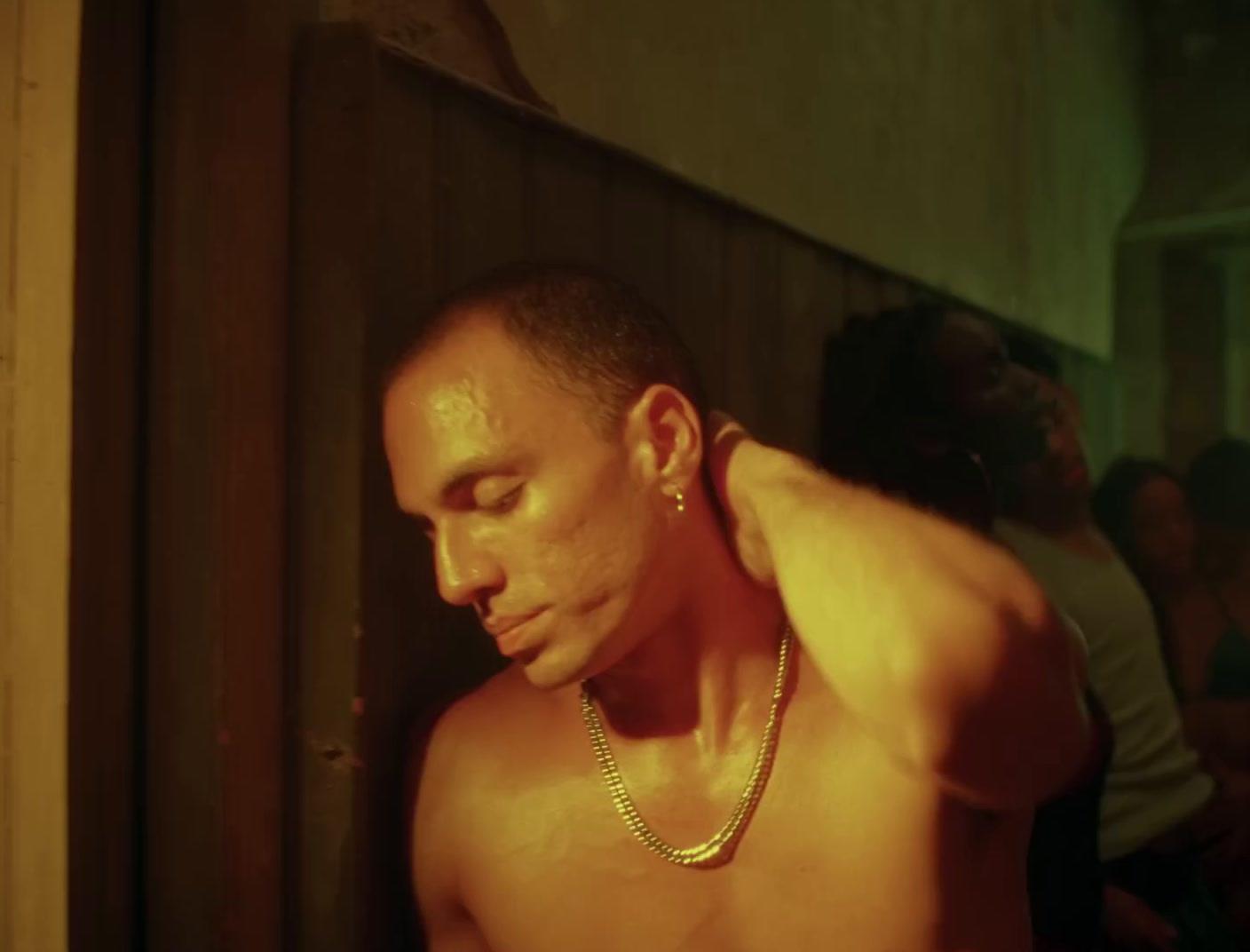 a shirtless man with a chain around his neck
