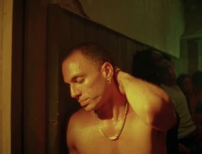 a shirtless man with a chain around his neck