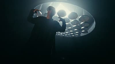 a man standing in front of a light fixture