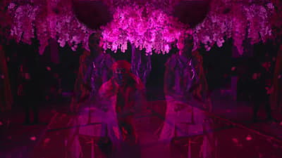 a woman sitting on a chair in a room with pink lights