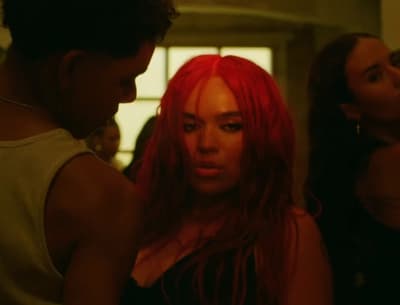 a woman with red hair standing next to a man