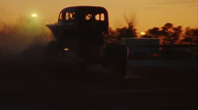 a tractor driving through a field at night