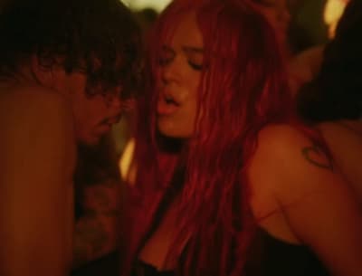 a woman with long red hair standing next to a man