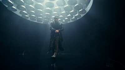 a man standing in front of a large light fixture