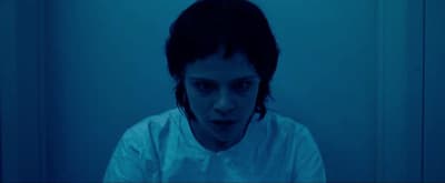 a man in a white shirt in a dark room