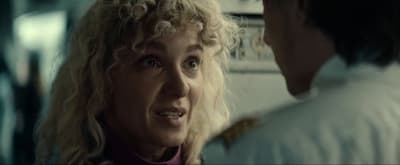 a woman talking to a man in a kitchen