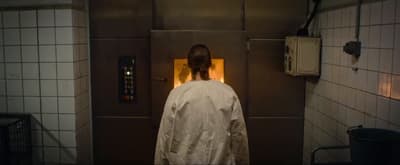 a person in a white robe standing in a bathroom