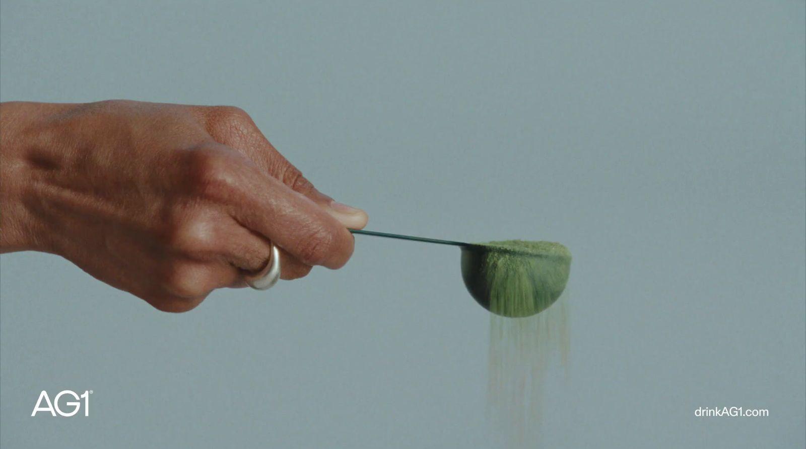 a hand holding a green object in the air