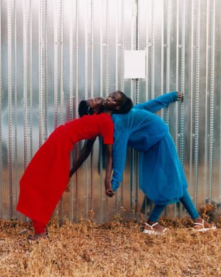 a couple of people that are leaning against a wall