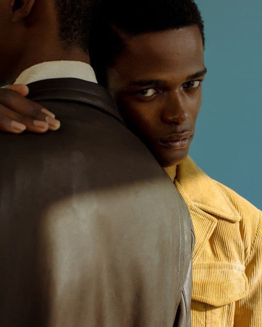 a man in a yellow shirt and a man in a brown jacket