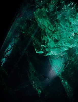 a close up of a green substance on a black background