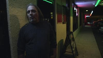 a man standing outside of a building at night