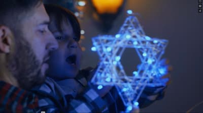a man and a child are looking at a star of david