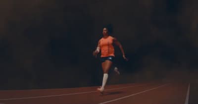 a woman is running on a track in the dark