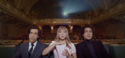 two men and a woman sitting in a theater