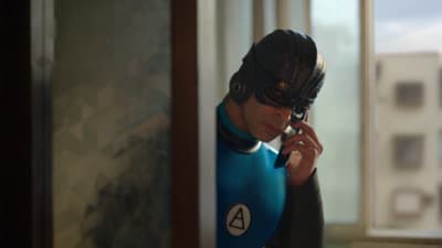 a man in a wet suit talking on a cell phone
