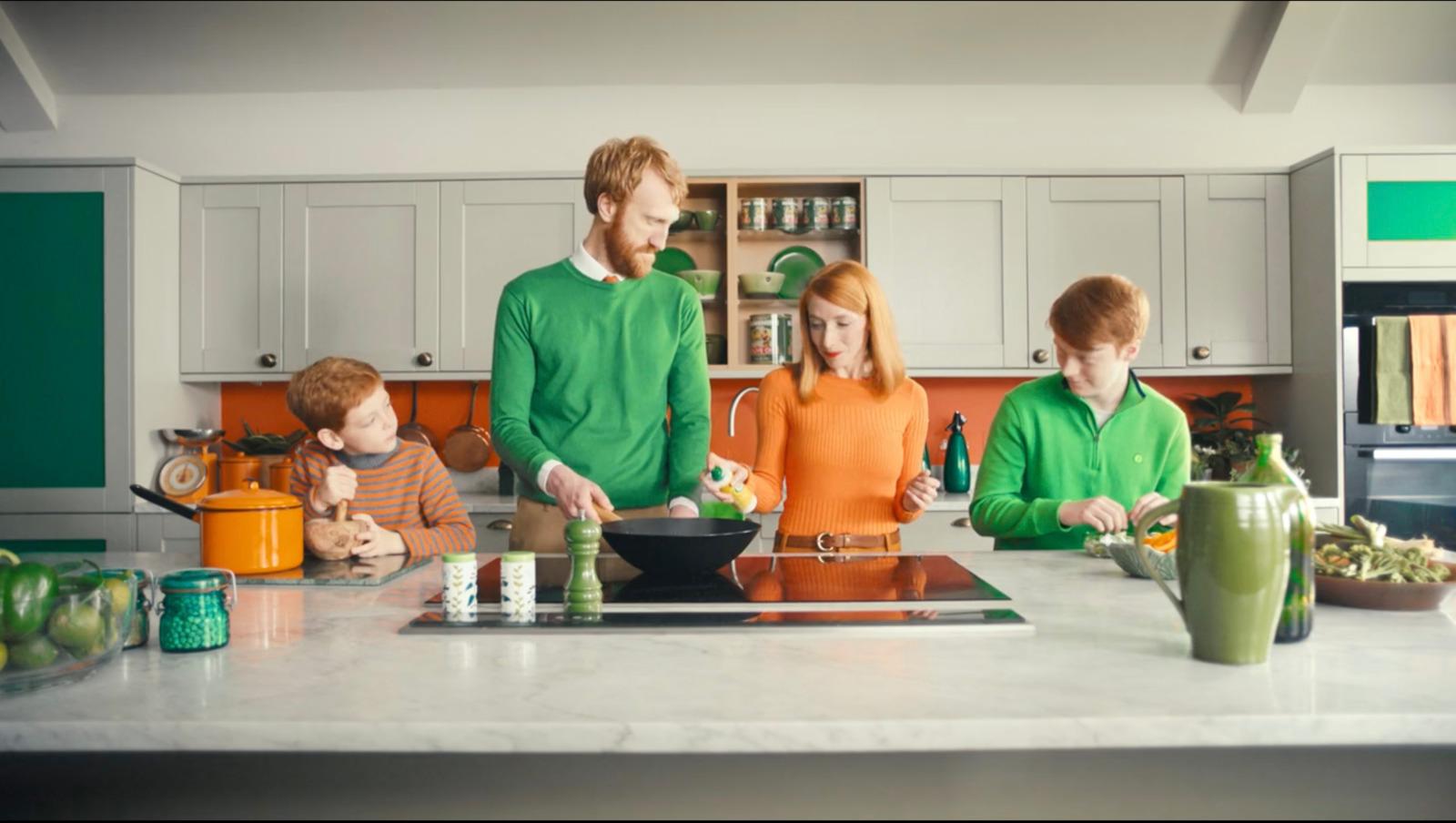 a group of people standing in a kitchen preparing food