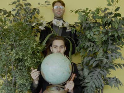 a man holding a globe in front of his face