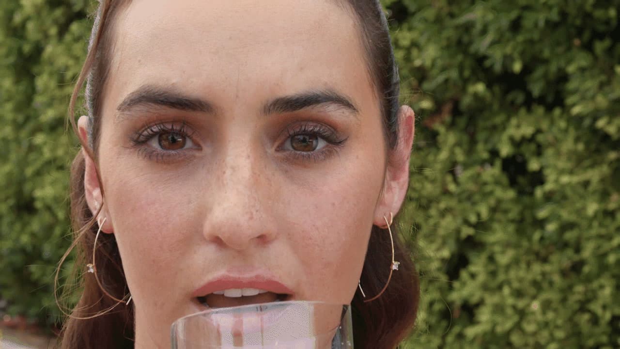 a woman holding a glass of wine in front of her face