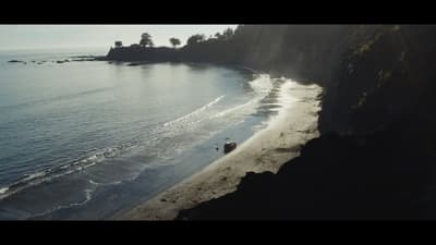 an aerial view of a beach with a boat in the water