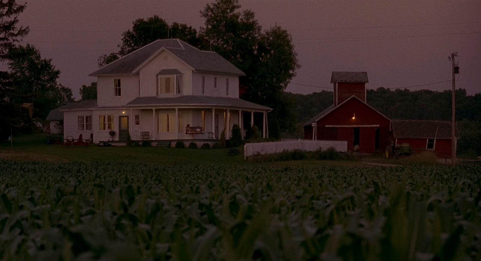 a large white house sitting on top of a lush green field