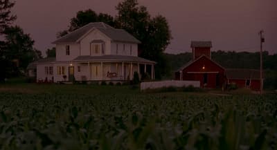a large white house sitting on top of a lush green field