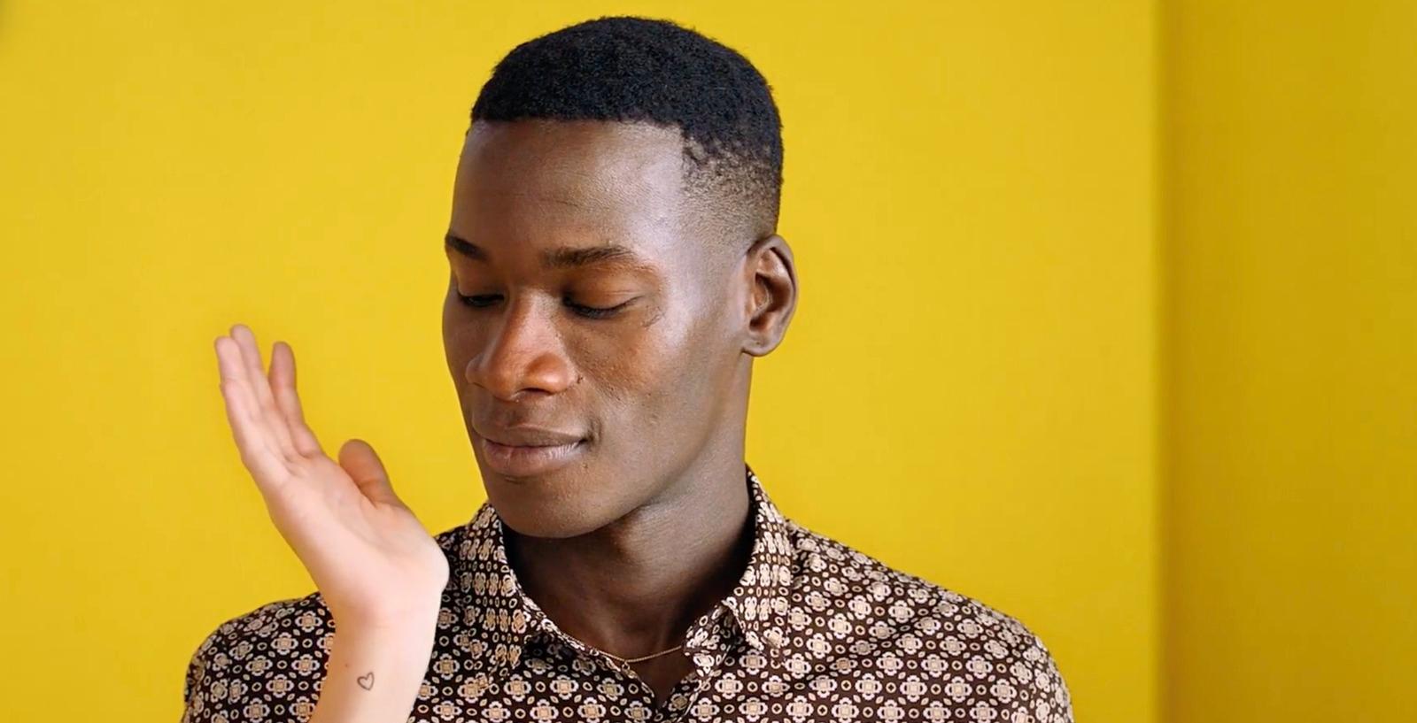 a man is holding his hand up in front of his face