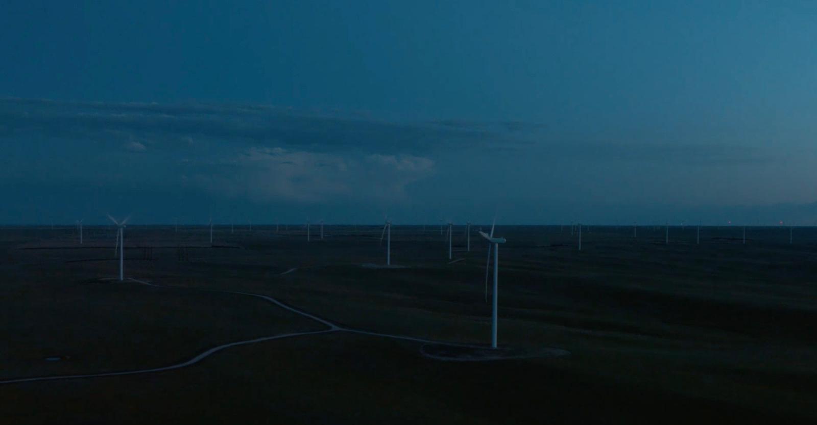 a group of wind turbines in a field at night