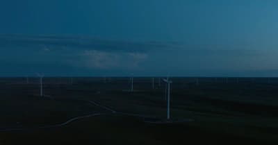 a group of wind turbines in a field at night