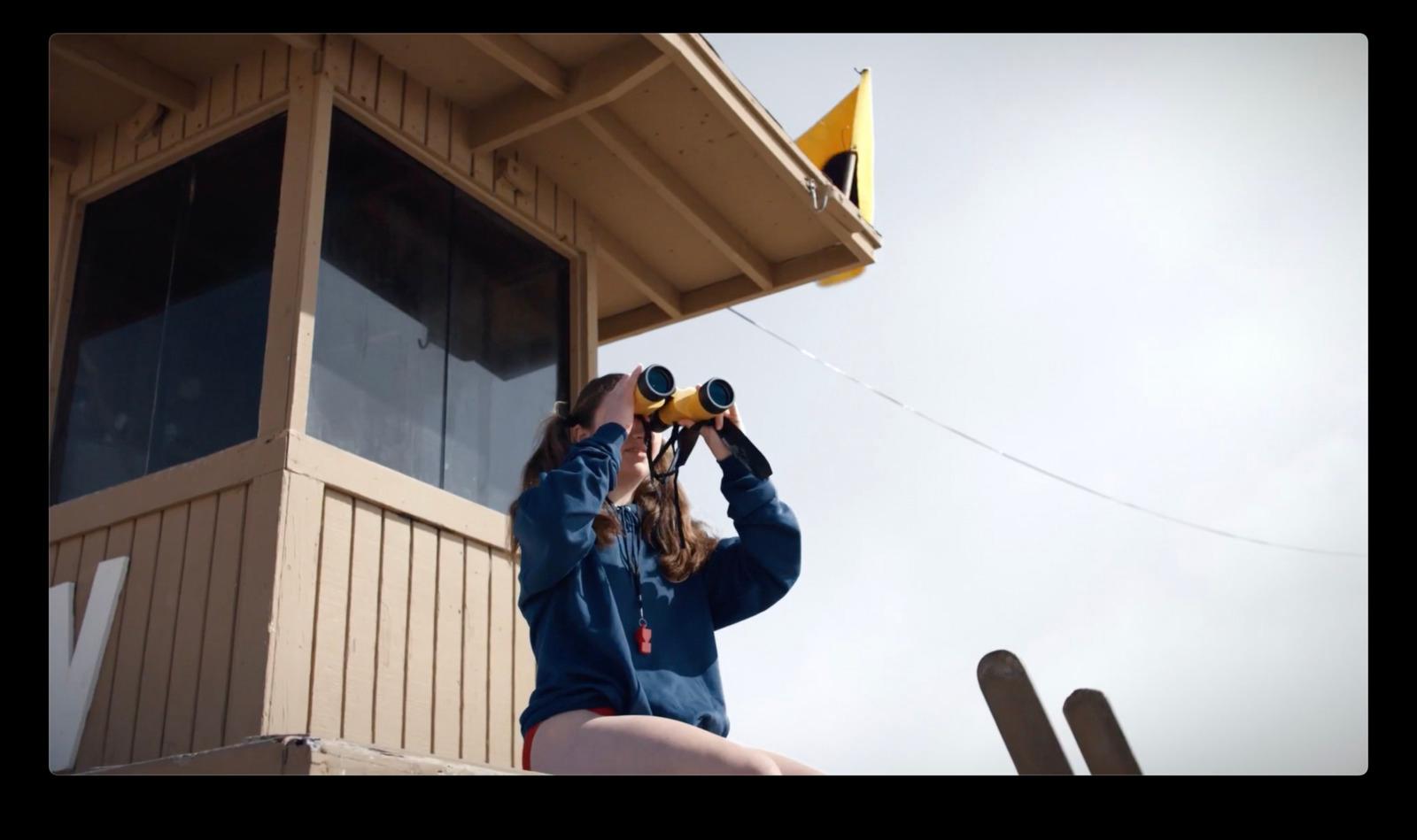 a woman looking through a pair of binoculars