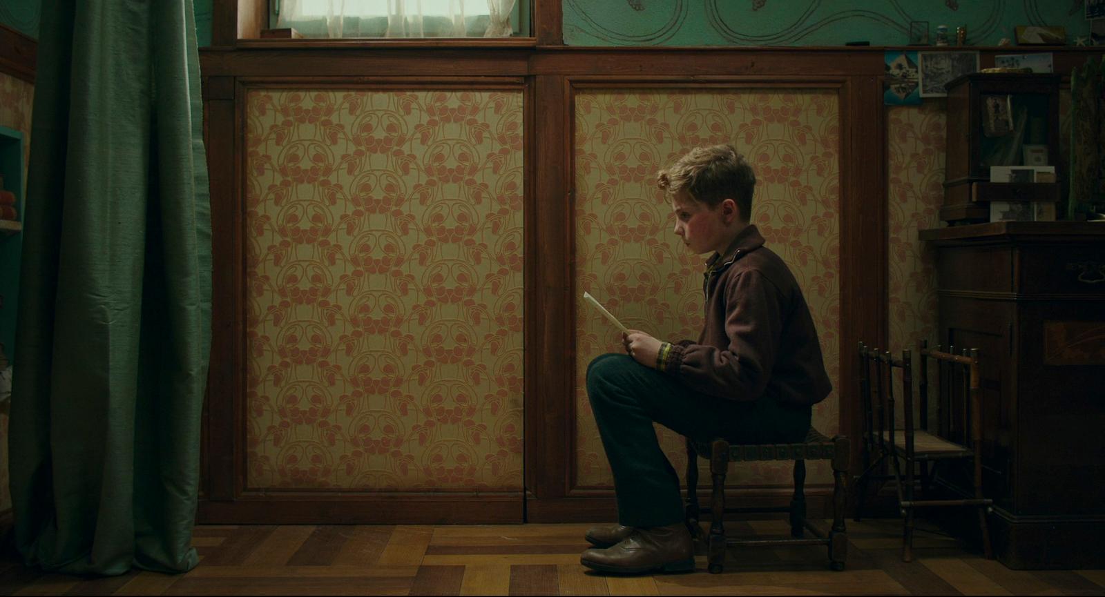 a man sitting on a chair in front of a window