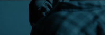 a woman with her eyes closed standing in a dark room