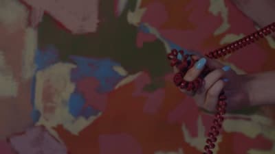 a woman holding a red beaded necklace in her hand