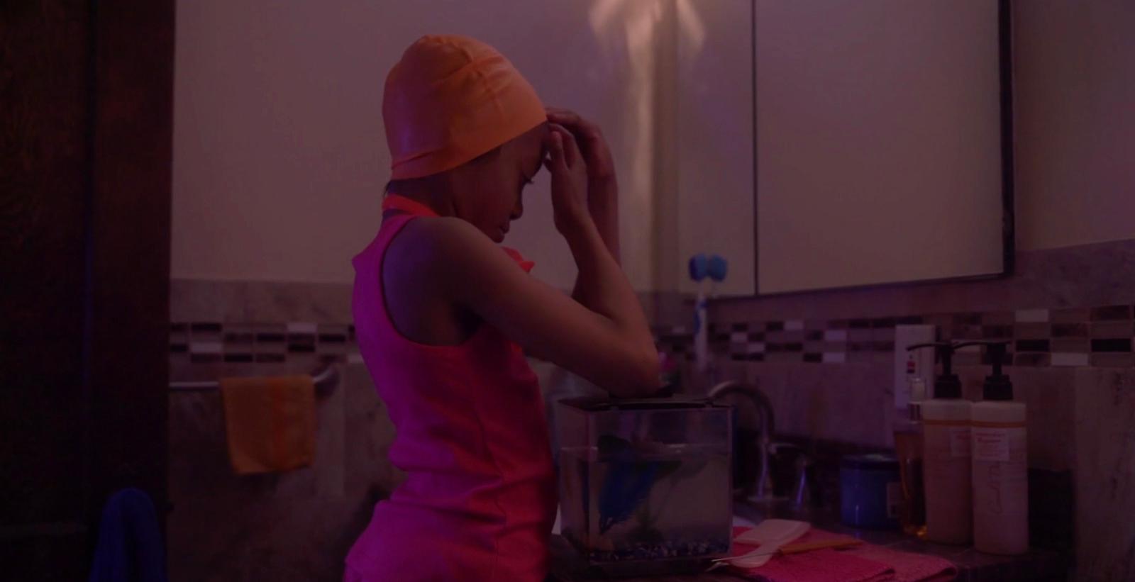 a woman in a pink dress is washing her hands