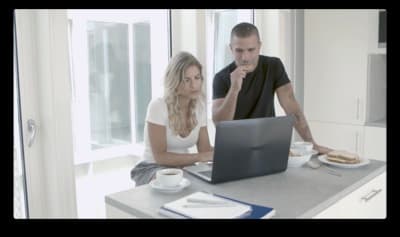 a man and a woman sitting at a table with a laptop