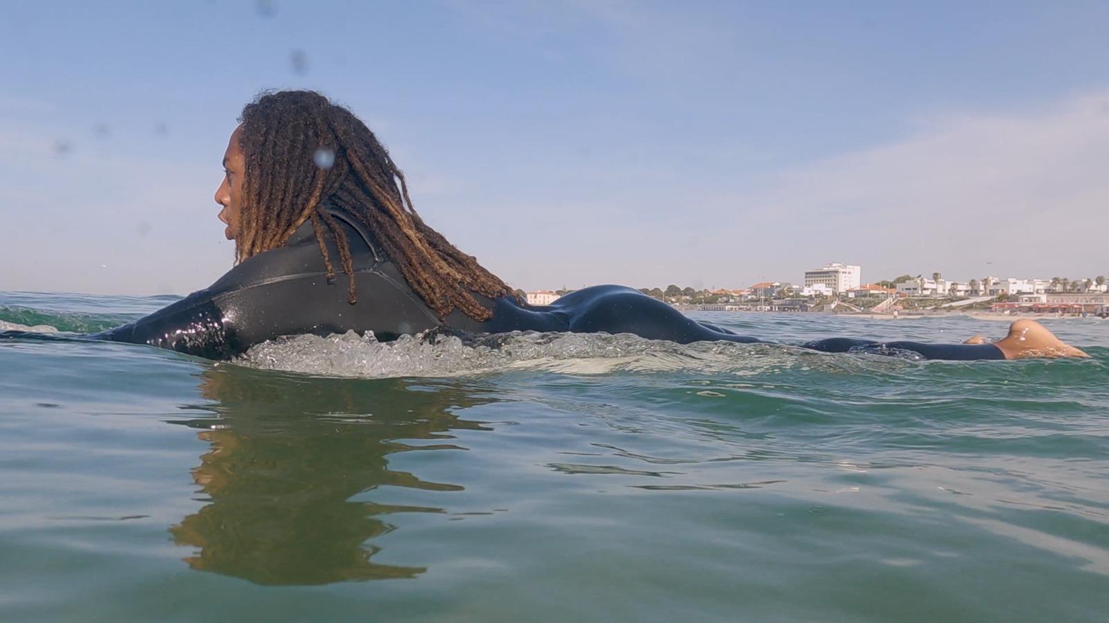 a woman laying on top of a surfboard in the ocean