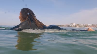 a woman laying on top of a surfboard in the ocean
