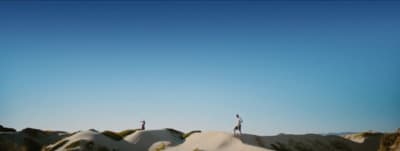 two people standing on top of a snow covered hill