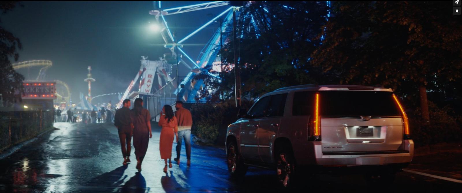 a group of people walking down a street at night