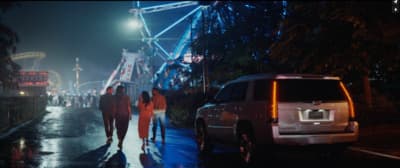 a group of people walking down a street at night