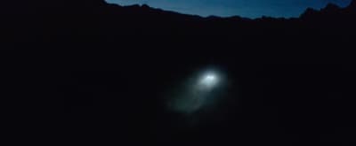 a street light in the middle of a dark mountain