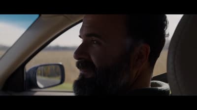 a man with a beard sitting in a car